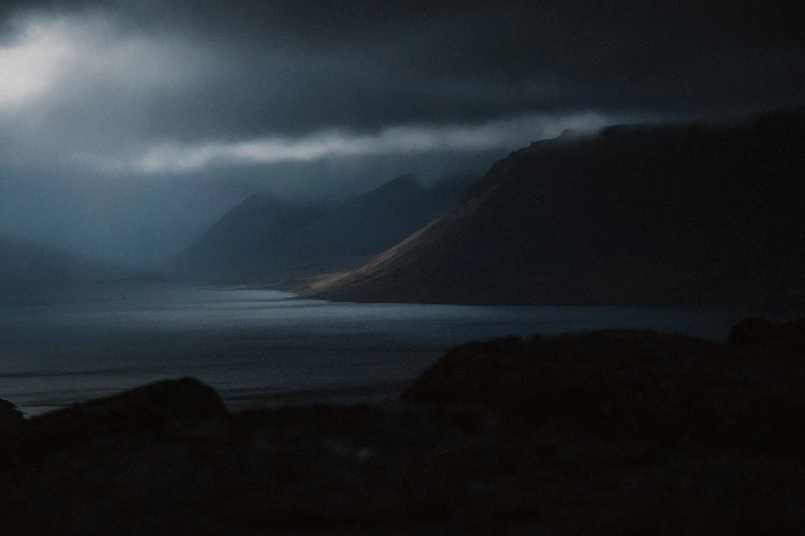 Fjord in den Westfjorden unter tiefen Wolken